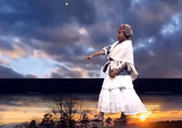 DianaStarr Raynell performs in front of a video backdrop for a presentation about Americans' passage from slavery.
