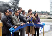 City Council members, City Manager Brad Miyake and Sound Transit CEO Julie Timm clip the ribbon for the reopening of the City Hall plaza.