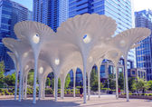 The artwork Piloti stands in the sun with people walking under it. Photo by Bellevue Downtown Association