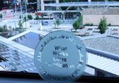 What Works Cities plaque leans against City Hall window, with plaza showing through the glass.